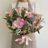 Large pink and white lilies mingle with delicate pink alstroemeria and cloud-like