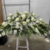 A sweeping all-white funeral spray designed to offer calm and dignity, this