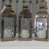 Three rose-gold lanterns with floral inserts and memorial quotes
