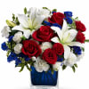 Striking red roses and large white lilies take center stage in this