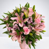 Pink lilies and roses arranged in a pink vase