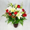 Bouquet of red roses and white lilies in a dark vase