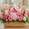 Soft pastels and a rustic woven basket make this flower arrangement an