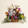 A lush, garden-style arrangement built low in a wicker basket-this flower arrangement