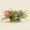 Coral and lavender roses take center stage in this garden-style wedding centerpiece