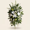 Tall white lilies and upward spires of snapdragons give this sympathy arrangement