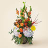 A dramatic vertical silhouette of orange roses, pale lavender and white hydrangeas