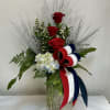 Three tall red roses rise above a cloud of pale blue and