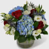 This stunning patriotic arrangement combines vibrant red roses, cool blue hydrangea, and