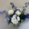 Sapphire Skies is a timeless arrangement featuring vibrant blue delphinium, lush blue