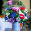 Mixed bouquet of roses and daisies in a blue ceramic mug