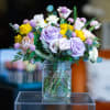 The design, flowers, and vessel used for this mini arrangement are left