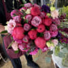 A lavish hand-tied bouquet where vibrant coral peonies meet elegant lavender roses