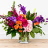 Vivid magenta roses and purple snapdragons create an immediate burst of color