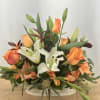 A lovely arrangement of white lilies and colorful roses, mixed with an