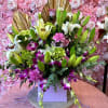 Large bouquet of lilies, orchids, and pink flowers in a box