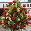 Tall arrangement of red roses and lilies in a glass vase