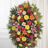 A vibrant standing spray that brings warmth and comfort to a sympathy