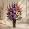 Lavender roses clustered with tall spikes of purple and pink snapdragons create