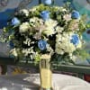 Bright blue roses and pale white hydrangea mingle with pink-striped alstroemeria, white