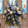 A serene, full spray of blue hydrangeas and white roses-this sympathy wreath