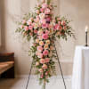 A large cross of soft pink and blush roses accented with white