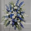 Blue and white blossoms arranged with coastal calm create a dignified sympathy