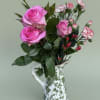 Two soft pink roses take center stage in this floral arrangement, making