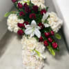 Cross-shaped arrangement of white roses with red roses and white lilies in the center