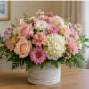 A lush rounded bouquet of blush pink, peach, and creamy white blooms