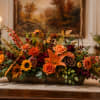 A low, wide autumn centerpiece bursting with warm-toned blooms-the perfect fall flower