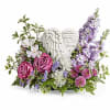 Pink roses and purple flowers arranged around angel figurines