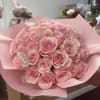 Bouquet of pink roses wrapped in pink paper with butterfly picks