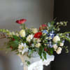 This beautiful flower arrangement of fresh mixed seasonal blooms is made by