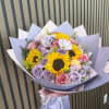 Bright sunflowers steal the show in this cheerful flower arrangement, balanced by
