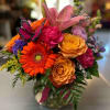 This vibrant arrangement is sure to be a hit, with Gerberas, roses