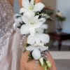 Pure white dendrobium orchids arranged vertically create a refined wrist corsage with