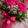 Vivid hot pink roses clustered in a compact nosegay make an immediate