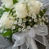Creamy white roses gathered in a compact, hand-tied nosegay create a quietly