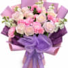 Soft blush and pale peach roses mingle with bright pink carnations and