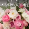 Pink and white standing wreath with layered blooms and palm fronds