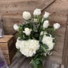 White roses and hydrangeas arranged in a glass vase