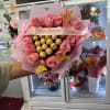 Soft pink roses gathered around a shimmering center of Ferrero Rocher chocolates
