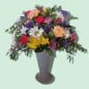A lively, rounded bouquet bursting with cheerful color-this mixed-color arrangement in a