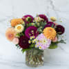A lively burst of color, this dahlia arrangement is made to make