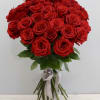 Large hand-tied bouquet of red roses with long stems tied by a silver ribbon