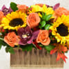 Sunflowers and peach roses in a rectangular vase with purple orchids