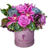 Pink roses and orchids arranged in a lavender hat box