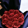 Round bouquet of glittery red roses wrapped in black paper