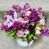 Pink and purple bouquet in a white container